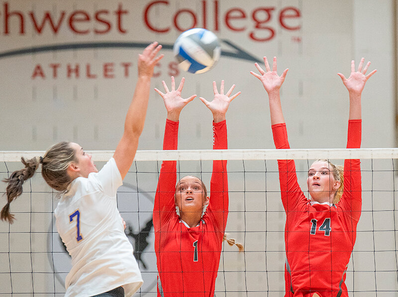 Kamri Hutchings (center) and Kennedy Oman (right) rise up for a block during the Trapper Invitational in August. Oman continues to grow in the Trapper&rsquo;s blocking game as the volleyball team will have a break before starting conference play next weekend.