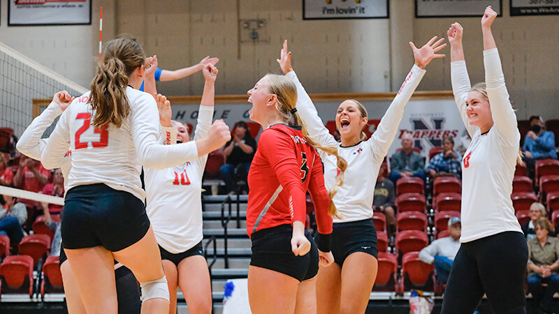 The Trappers celebrate with Taylor Wilson (23) after a kill against Eastern Wyoming. The Trappers (from left) are Sierra Kilts, Ellie Thomas, Kamri Hutchings and Elsa Clark.