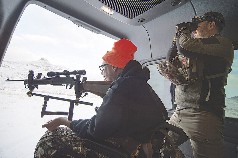 Scotty Rae Hettinger prepares to line up a shot from his wheelchair while on a guided trip with the Wyoming Disabled Hunters as volunteer Myles Haines helps to decide on a target. Hettinger was one of 20 hunters with disabilities to be included in the group&rsquo;s 2023 season.