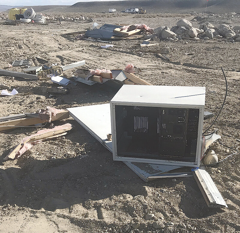 Communications equipment destroyed in a wind storm that resulted in a fatal fire is seen littered across the Line Creek landscape as teams attempt to salvage parts and reconnect the important communications devices. The building was replaced recently with a &lsquo;bullet-proof&rsquo; structure.