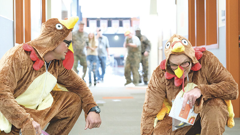 Assistant Principal Chanler Buck (left) strategizes with Principal Kyle Rohrer during Powell Middle School&rsquo;s annual Turkey hunt on Nov. 21. This year the administrators costumes and accessories, which included feathers and &lsquo;turkey poop,&rsquo; were given an upgrade thanks to IMC clerk Jill Morrow.