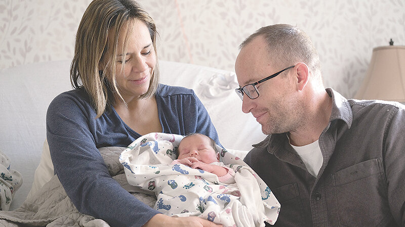 Erin Robertson (left) holds her new baby Lydia Rose Robertson close alongside her husband Jake Robertson. Lydia holds the distinction of being Powell&rsquo;s first baby of the new year.