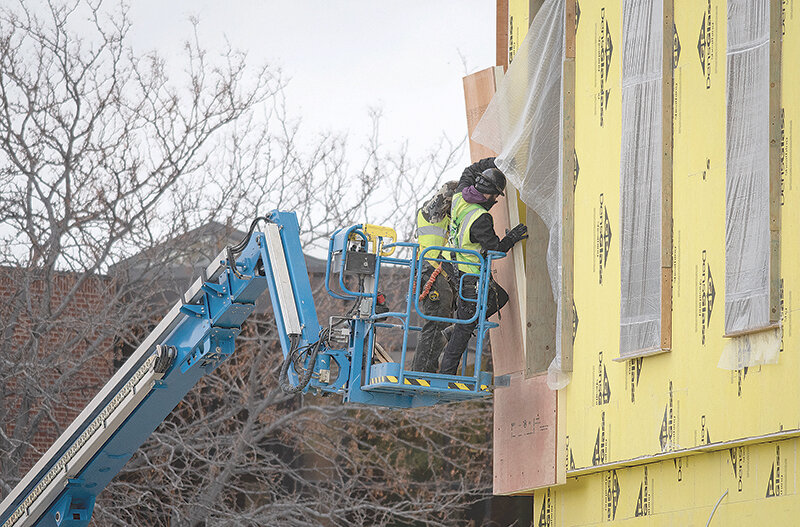 Workers brave the cold to work on the exterior of the new Northwest College Student Center building, which remains on schedule for an August completion.