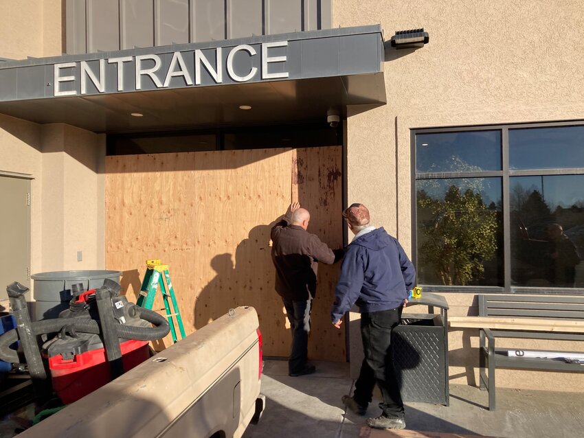 Workers board up the entrance to the Powell emergency room on Saturday morning, hours after a truck crashed through the doors.