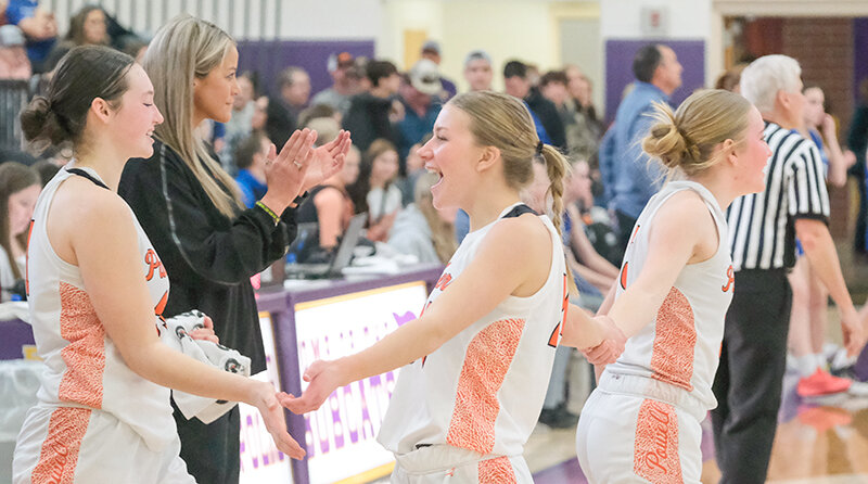 Lauryn Bennett (center) celebrates with Saige Kidd (left) and Ivy Agee as coach Chelsea Kistler cheers after the Panthers secured their spot at the state tournament.