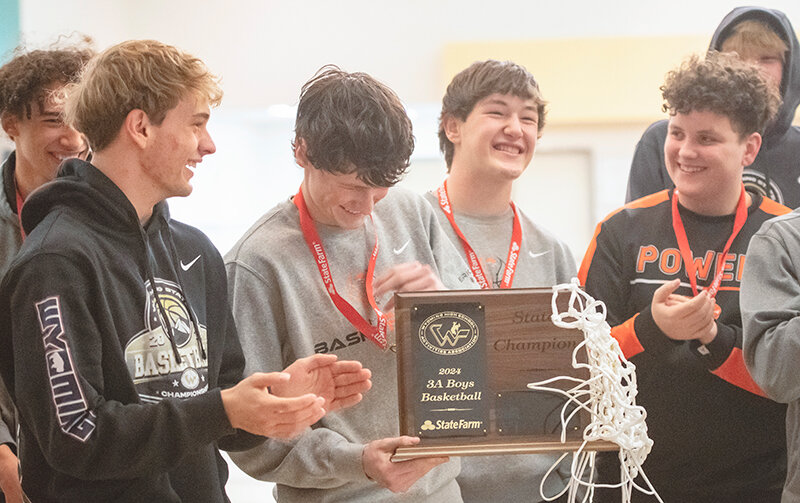 The Panthers stand around with the championship trophy, celebrating with the crowd at Powell High School after returning home late Saturday night. From left: Alex Jordan (behind), Dawson Griffin, Gunnar Erickson, Jhett Schwahn and Park Harvison.