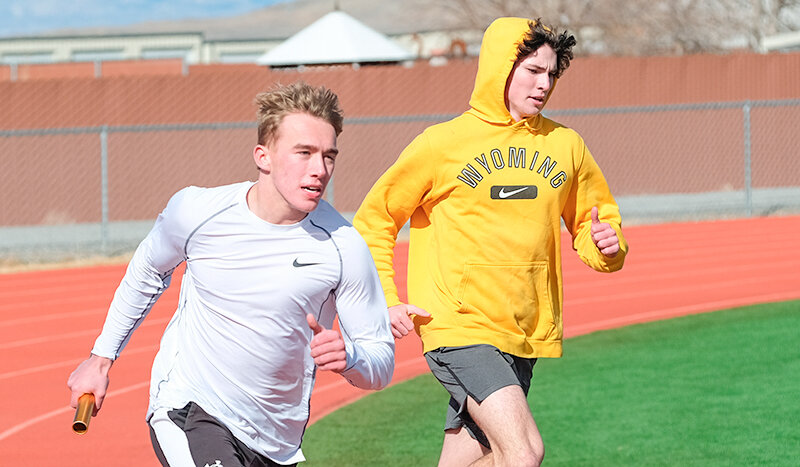 Evan Whitlock (left) races on the track after receiving the baton from Caden Nelson during practice, as the Panthers have been practicing ahead of the first competition this week.