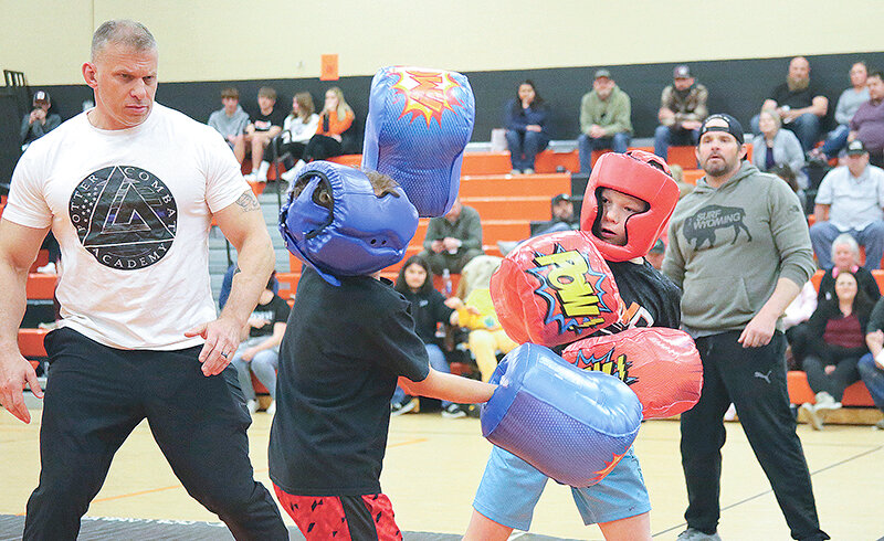 Jason Potter (left), owner of Potter Self Defense Academy, carefully watches an exhibition match between Case Cottonware and Tobyn Jordan on March 25 as part of the Post 26 Big Horn Boxing Club&rsquo;s first fight night in the Powell Middle School gym. Behind them is coach Ryan Green.