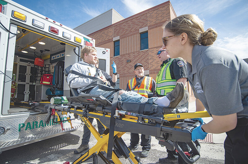 Northwest College nursing student Loui McKinney (right) loads NWC wrestler Josh Womack into the back of a Cody Regional Health ambulance during a mock mass casualty training event at school while Powell Valley Healthcare EMS manager Scott Bagnell and Cody Regional Health EMS Director Phillip Franklin offer instruction. Nursing, Emergency Medical Services and Outdoor Education students dealt with fake injuries to 32 student athletes Tuesday on campus.