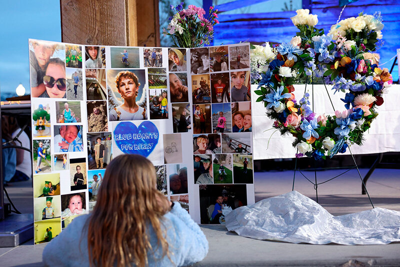 A mourner looks at photos of Bobby Maher prior to a vigil in his memory Thursday in Casper.