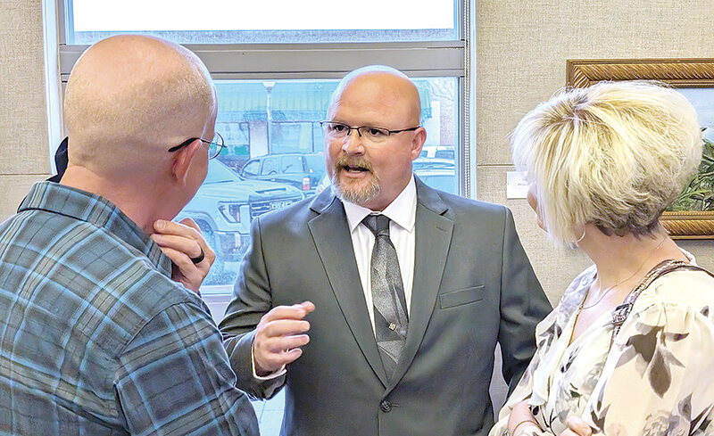 Holcomb, Kansas, Police Chief Cory Williams and his wife, Kim (at right), visit with Tim Morrow (at left) during a Thursday evening event at Plaza Diane. Williams is one of four finalists to become Powell’s next police chief.