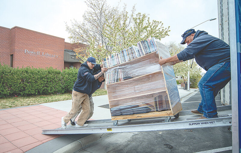 Phil Wallace and Zack Jones of Cook Moving and Storage and Park County employee Felipe Serna move the last rack of books into the moving van Wednesday on its way to Homesteader Hall at the Park County Fairgrounds.