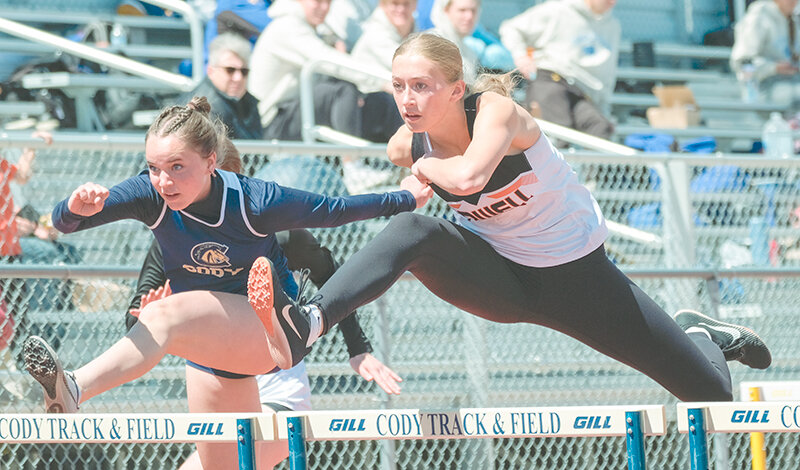 Addy Thorington (right) battles against a Cody hurdler on Thursday. Thorington claimed a share of the title in the high jump Thursday before winning it outright on Friday in Thermopolis.