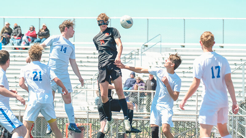 Tevon Schultz (center) rises up to contest for a header on a corner kick against Lyman on Saturday. Powell locked up a state tournament berth on Saturday after two straight 1-0 victories at home.