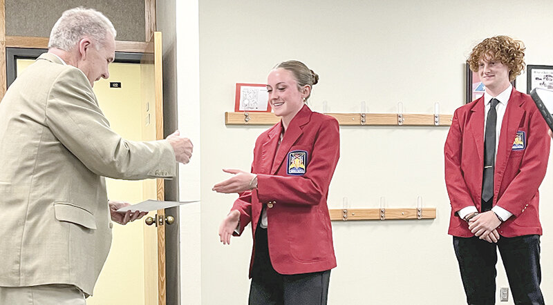 Park County School District 1 Board Chair Kim Dillivan (left) gets ready to shake Kinley Cooley&rsquo;s hand while Keegan Hicswa stands behind her during a May board meeting where the two SkillsUSA members were recognized for their first place wins at the state level. Both Cooley and Hicswa will compete at SkillsUSA&rsquo;s National Leadership and Skills Conference in Atlanta the week of June 24.