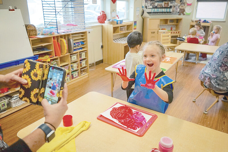 Preschooler Madilyn Liechty shows off her hands to teacher Dolores Synegard while doing an art project at the Evanston Child Development Center in 2023.