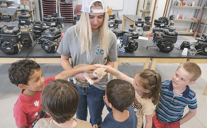 Tori Black (center) shows off Sunny the kitten at the Powell High School Ag Barn in May. It just so happened that was also FFA Petting Zoo day. From left, Parkside Elementary School student Jace Saravia, Black, Dakota Kryger and Levi Burke.