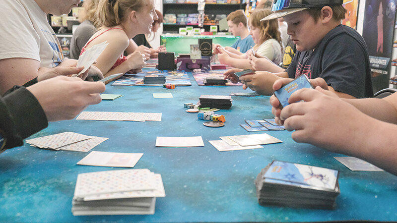 Players hold their hands during a recent Pokemon tournament at The Game Vault, the second game store to open in town this year.