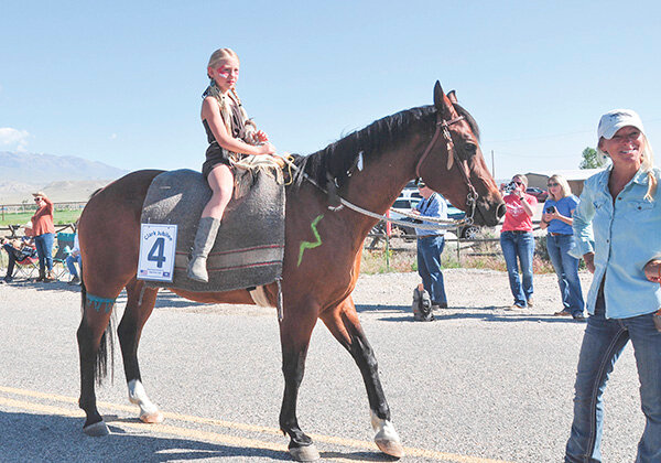 Kallie Rae Hoffert rides the horse named Cowboy as mom Ely Hoffert leads the way during the Clark Jubilee parade last Saturday.