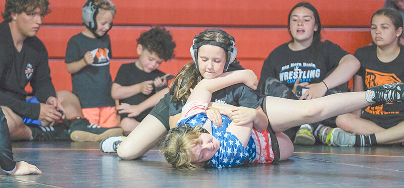 Nova Burbank (top) holds down Tori Howard during the duals at the Big Horn Basin Wrestling Camp in early June.