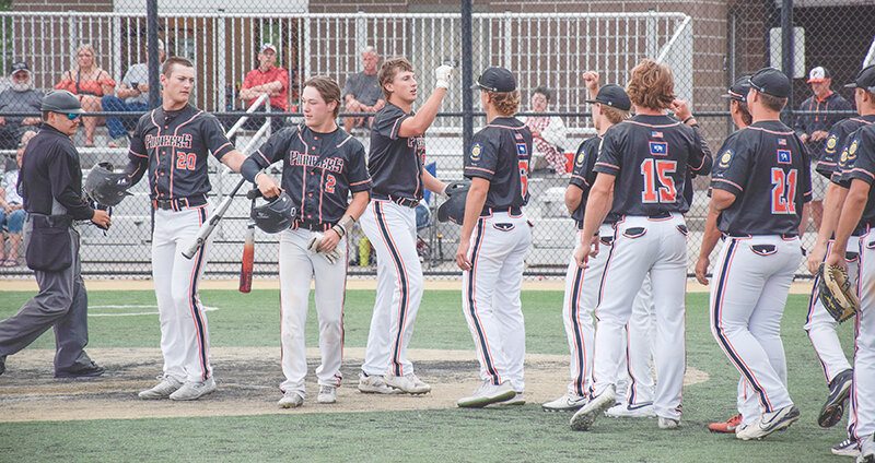 The Pioneers celebrate with Cade Queen after he hit one of his two home runs against the Cheyenne Hawks on the Fourth of July.