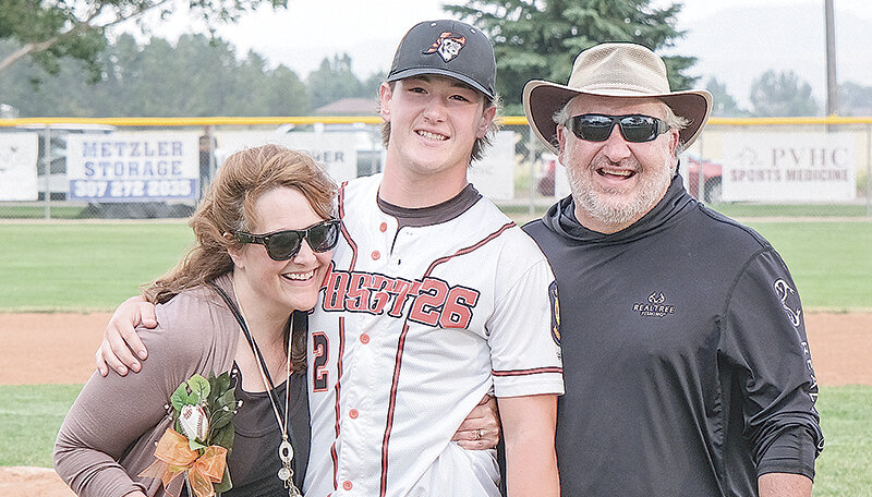 Jhett Schwahn (center) celebrates senior night with the Powell Pioneers on Thursday, accompanied by his parents Lisa and Russ.