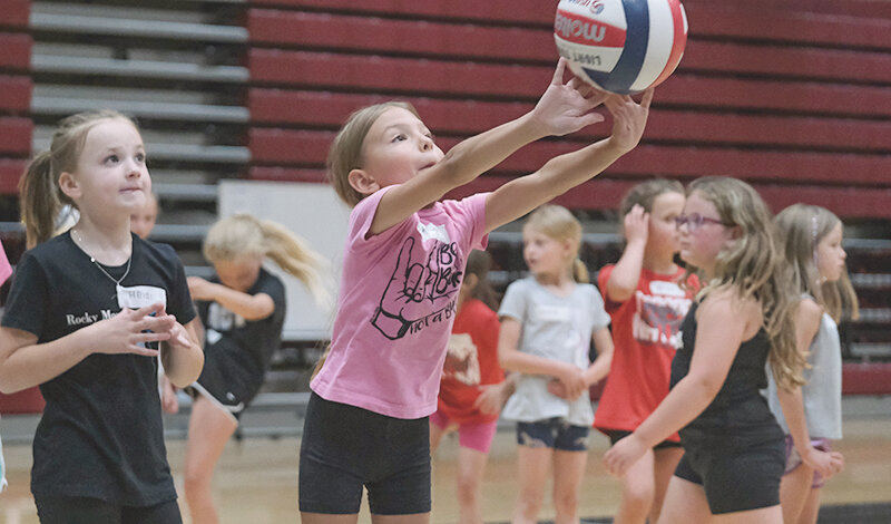 Amelia Paul sets the ball during a drill, with younger athletes spending time in the gym with Northwest College athletes to learn the game of volleyball.