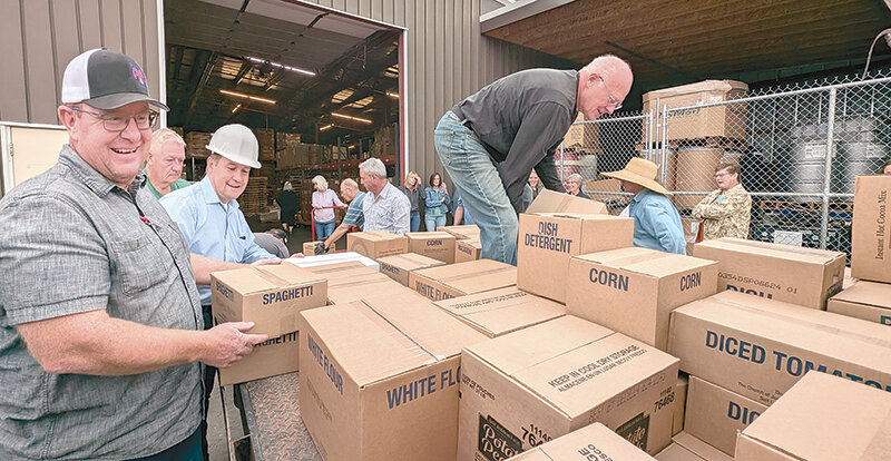 Volunteers, including Seth George (at left), help Mike Moncur (on truck) load spaghetti, corn, diced tomatoes, flour and other items for Northwest College’s TriO Support Services. The boxes were among 16 tons of commodities that Latter-day Saint Charities provided to 16 local nonprofit organizations and churches.