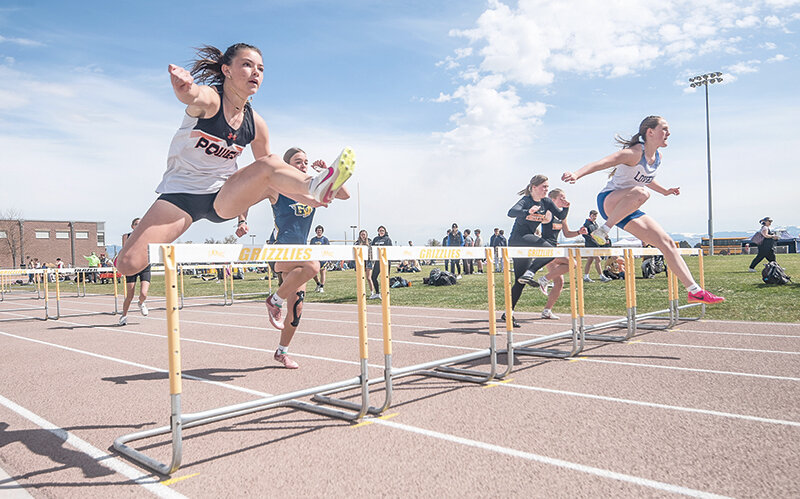 Abigail Visocky (left) clears a hurdle during the 100 meter hurdles on Saturday in Cowley. The Panthers took the team title with 186.5 points.