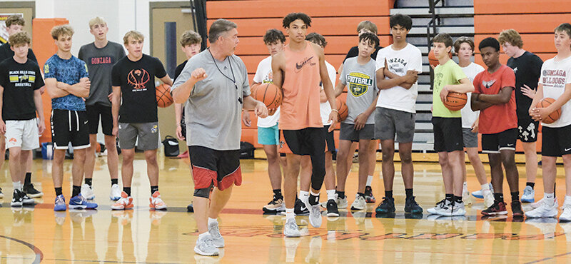 Northwest College coach Andy Ward (left) shows a drill alongside then Powell High School player Alex Jordan (center) during the Trapper and Panther Boys’ Basketball Camp in 2024. The camp kicks off Monday at Powell High School.