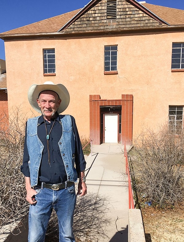 Flint Carter of Oracle, Arizona, stands in front of the former Mountain View Hotel, built in 1895. Buffalo Bill Cody was said to be an owner. The porch has been removed from the two-story stucco building, and it sags in disuse. The property is owned by the Southern Baptist Church there.