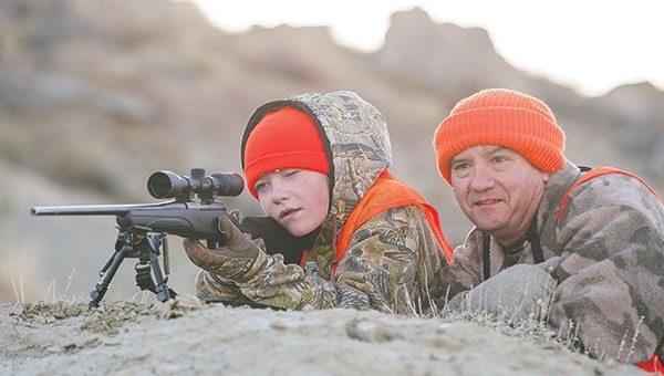 Shelby Fagan and her father Frank, both of Powell, check the status of her harvested deer through the scope after Shelby pulled the trigger on her first big game animal.