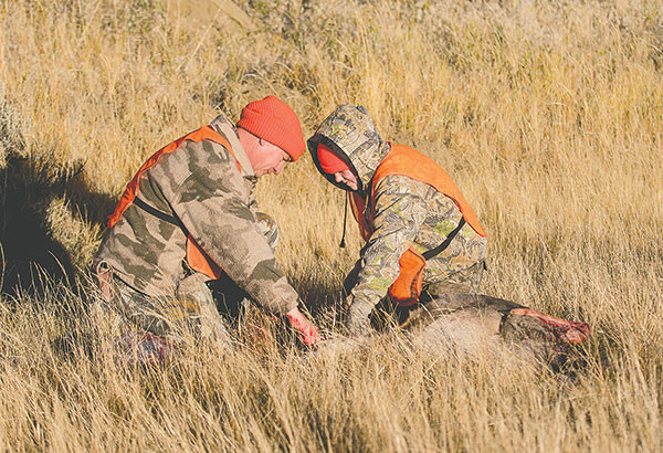 Frank Fagan and his daughter Shelby field dress a doe Shelby harvested — her first.