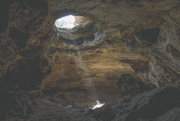 A beam of light illuminates a researcher at the base of the Natural Trap Cave near Lovell. The cave will be closed, possibly for decades, after the research staff of Julie Meachen finishes its work Saturday. Photo courtesy Justin Sipla