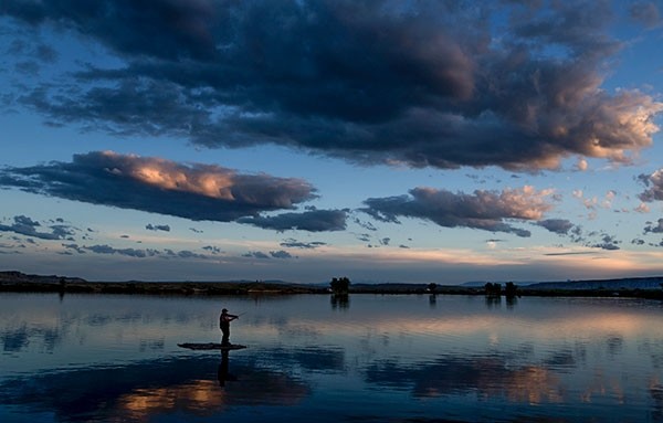 A fisherman throws a lure from a small rocky island at Deaver Reservoir, near Deaver, at around sunset. The facility, built in 1918, is a good fishing spot, especially in winter and early Spring.