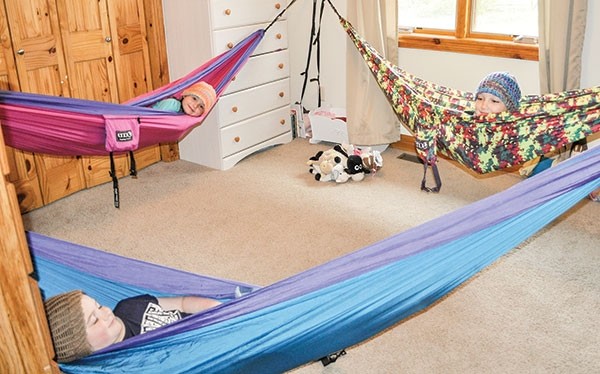 The Mason kids started sleeping in hammocks last summer, and now prefer their hammocks to beds. Sisters Lily, 7, (foreground), Faith, 6, (left) and Danica, 10, (right) share a room. Instead of making beds in the morning, they simply fold up their hammocks, leaving the bedroom open for the kids to play. Lily made hats so the girls’ hair doesn’t get staticky.