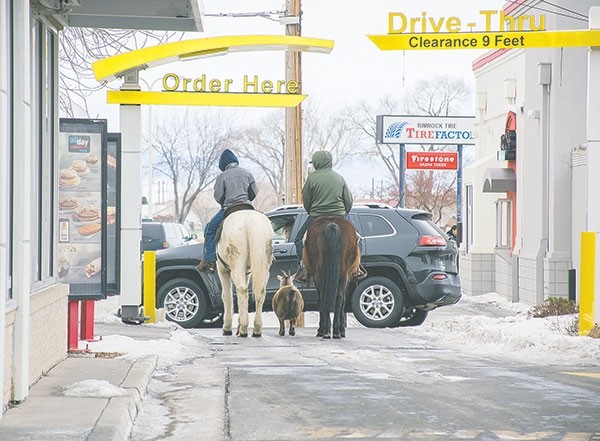 Trajen Collins (left) and Joel Perez drew attention in town and on social media when they rode their horses through the Powell McDonald’s drive-thru with a pet goat in tow last week. This photo had been shared more than 3,570 times on Facebook on Wednesday, reaching nearly 430,000 people.