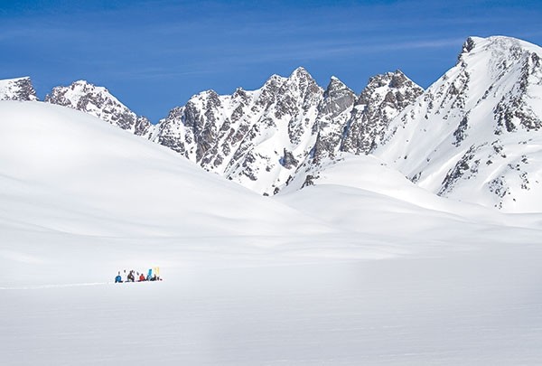 Skiers on Goose Lake, just outside Cooke City, Montana, are dwarfed by rolling hills of snow set against the craggy mountaintops in this photo taken by Kathy Lichtendahl of Clark. The shot is included with her story in the December issue of ‘Outdoor Photographer.’