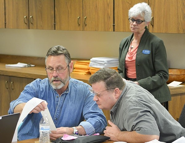 Park County employee Doug Smith reads off printed results from one of the voting machines during Monday’s recount of the Senate District 18 race, while Robert Sibley — an observer for candidate Cindy Baldwin — takes a good look. Park County Clerk Colleen Renner is shown looking on.