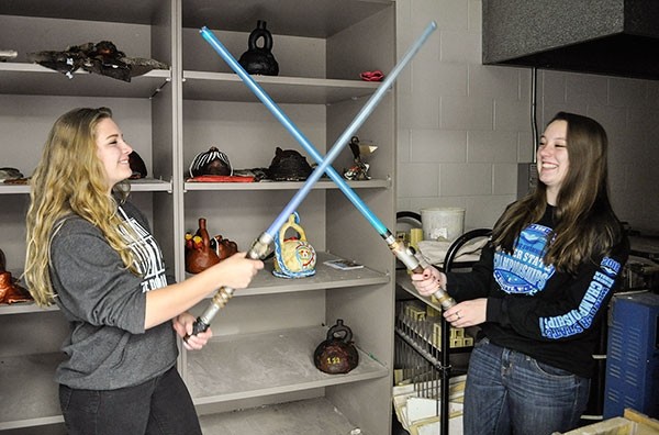 PHS art students Claire Miner (left) and Bethany McCaslin duel with their lightsabers on May 26.