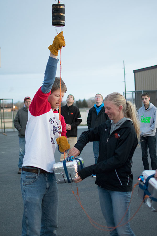 PHS student Delaney Dent (right) assists Phil Bergmaier with one of three payload boxes, which were filled with various experiments. Bergmaier is a graduate fellow in atmospheric science with the University of Wyoming Science Posse. Tribune photo by Steve Johnston