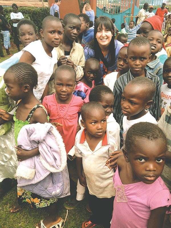 Kendra VanGrinsven is pictured with kids in Kenya. VanGrinsven is concerned about the number of children who don’t have shoes, so she and other volunteers are collecting shoes to send for Christmas  (see details in the story below).
