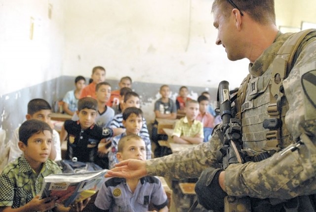 Powell native Capt. Carl Danko, commander of Company C, 2nd Battalion, 5th Cavalry Regiment, 1st Brigade, 1st Cavalry Division, gives a package of school supplies to a student attending the Tunis Primary School on Monday, Oct. 3. Soldiers assigned to the Lancer battalion helped distribute school supplies with the IPs to strengthen the bond between the ISF and the Iraqi populace before U.S. forces permanently leave Iraq at the year’s end.