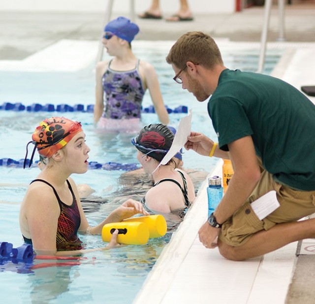 Lady Panther swim coach Luke Robertson consults with Bianca Larson during the team’s Monday practice. Larson is one of a number of freshmen who has turned out this year, and Robertson will have 31 swimmers in the water this season.
