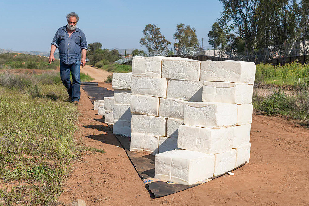 Using blocks of spoiled cheese, Cosimo Cavallaro is building a wall at the U.S.-Mexico border. Cavallaro brought his unusual artwork to Powell in 2001, when he covered a small cottage with cheese.