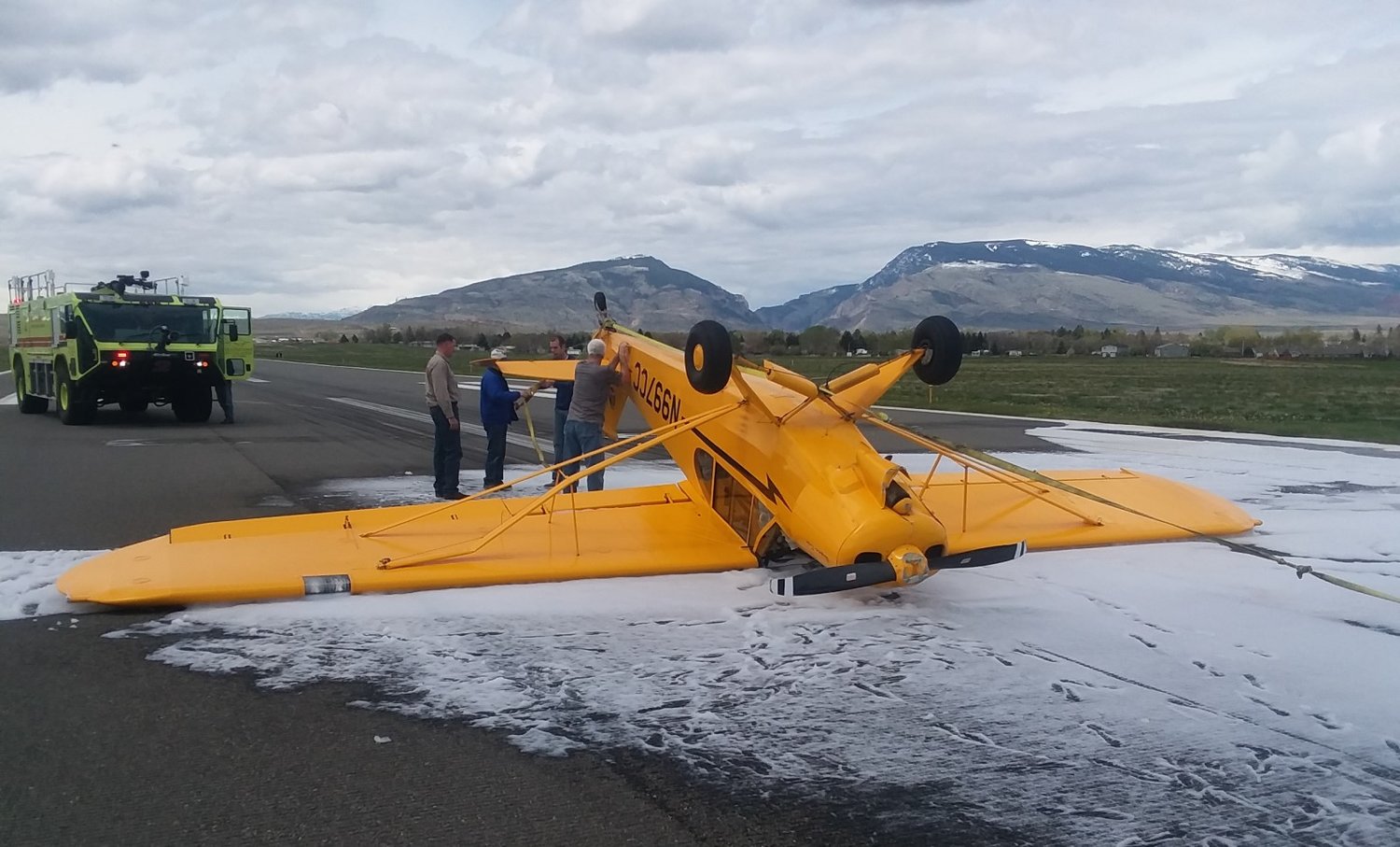 A Piper Cub rests upside down on the Yellowstone Regional Airport runway on Saturday morning, after flipping over during landing.