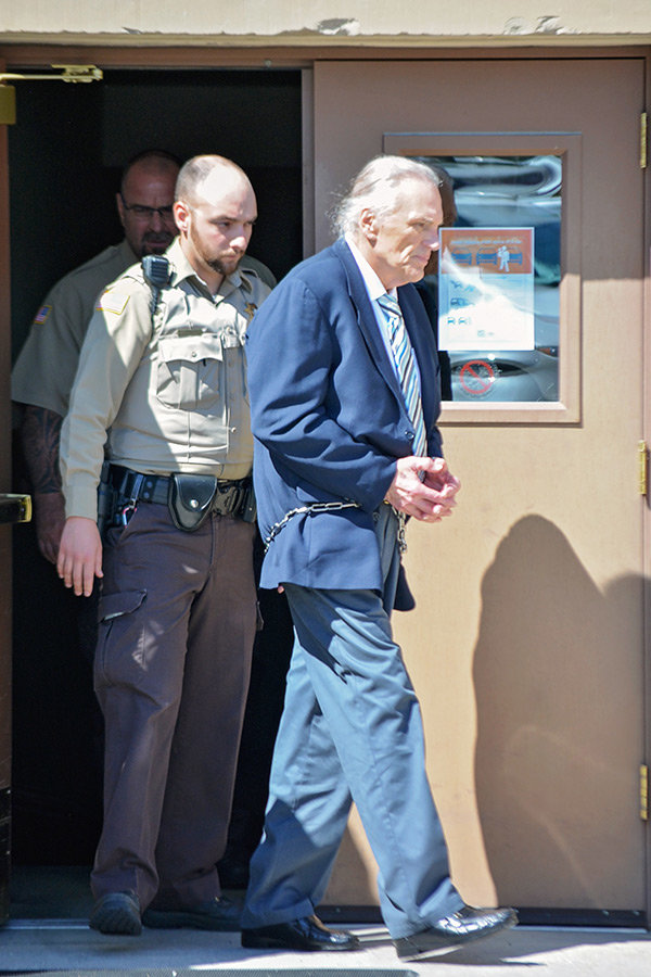 Dennis Klingbeil is led out of the Park County Courthouse in a suit and shackles on Friday afternoon after being convicted of first-degree murder. He killed his wife, 75-year-old Donna Klingbeil, at their home in Wapiti last year.