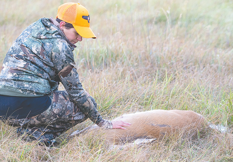 After taking a lethal shot on a white-tailed doe near Meeteetse, Sarah Hamlin takes a minute of silence with her prey. ‘Women tend to express a higher level of sentiment for the animal after the harvest,’ said her mentor, Fred Williams.