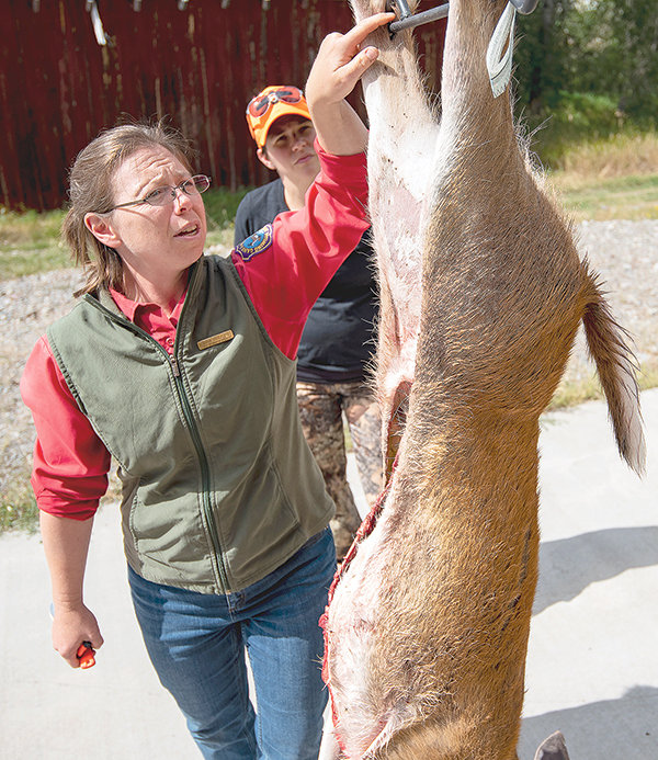 Tara Hodges, information and education specialist with the Wyoming Game and Fish, helps Sarah Hamlin process her deer. Hodges volunteered her time to mentor hunters in the women’s group Sisters of the Sage.