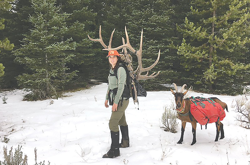 Desarae Starck poses with the head and antlers of her six-point trophy elk Tuesday morning alongside one of her family’s goats. Starck is the treasurer for the North American Packgoat Association. She and her husband, Justin, have been training their goats for three years.